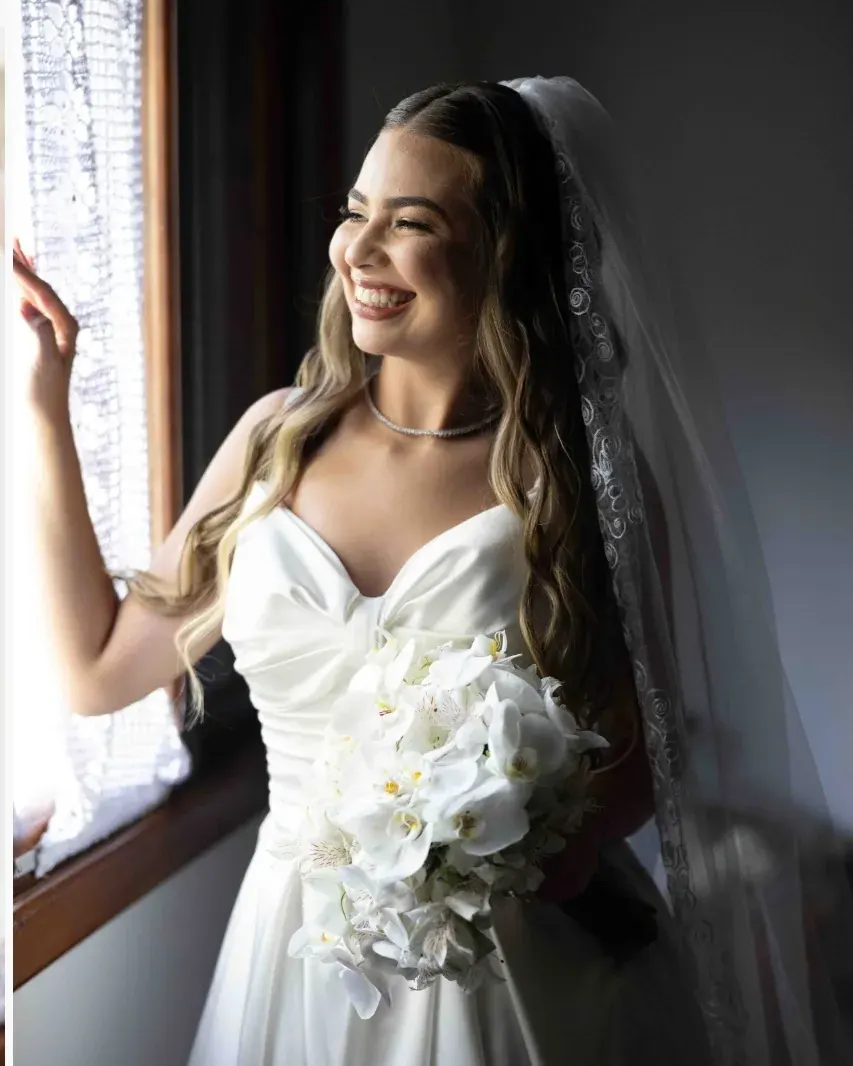 Noiva sorrindo na janela
